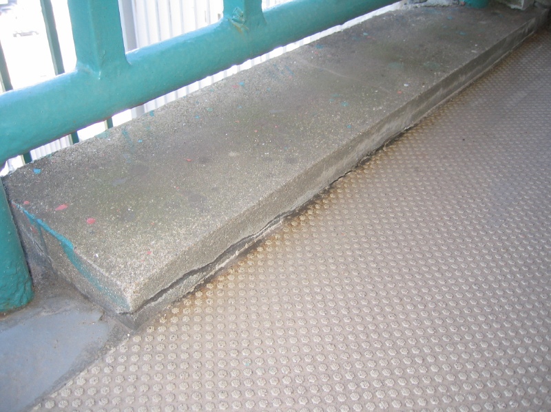 共用廊下　手摺足元のモルタルの浮き。下部にひび割れが生じている。