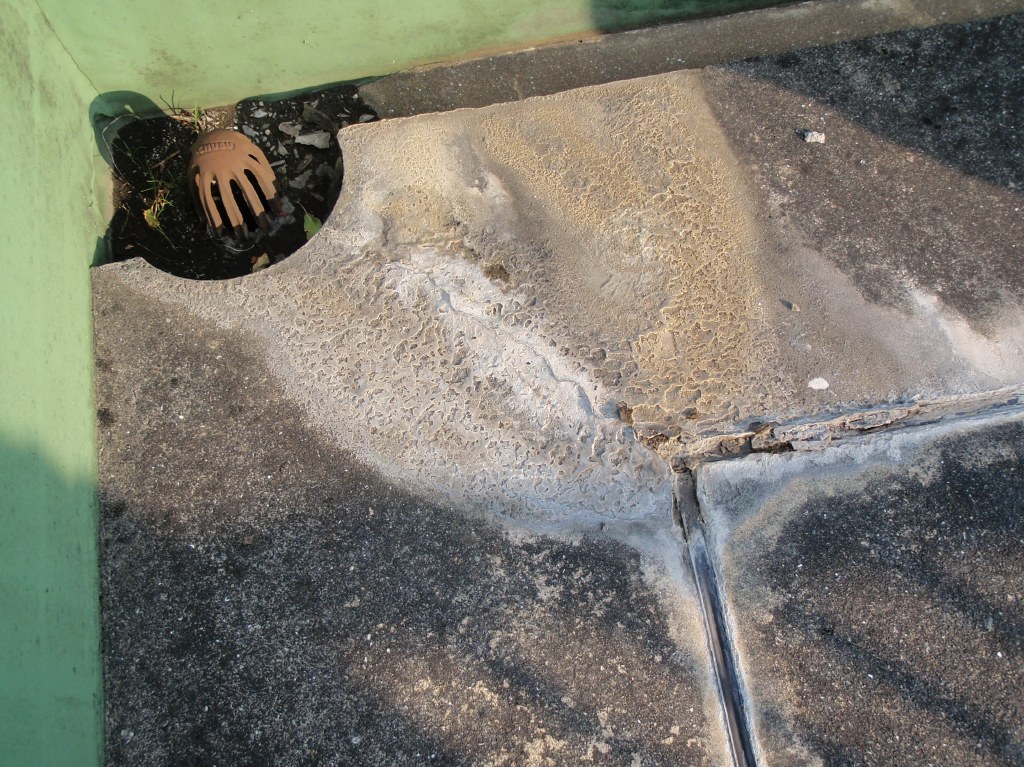 押えコンクリートの表面に、白いもの（コンクリートの成分の石灰質）が流れ出している。