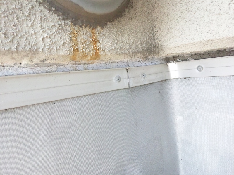 ゴムシート防水の端末部。水切りがないので、壁をつたった雨水が防水層端末のシーリング材の上を直接流れるので、劣化が早い。ここの例では、紫外線でも劣化が促進されている。