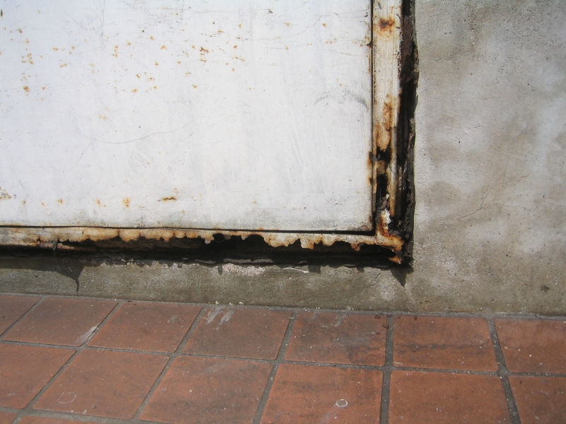 錆が進行し腐食が進み、朽ちた鉄扉の枠。劣化の場所によっては非常に危険である。又、取替には多額の費用が掛かる。