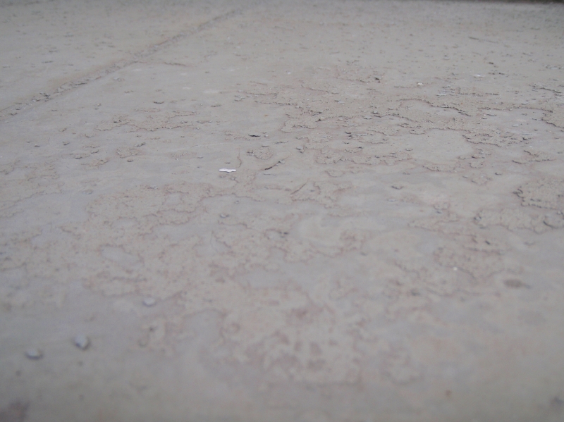 バルコニー床面に施工された塗膜防水。トップコートが粉状になっている。防水補修する前に、弱い部分を全てケレンする必要がある。