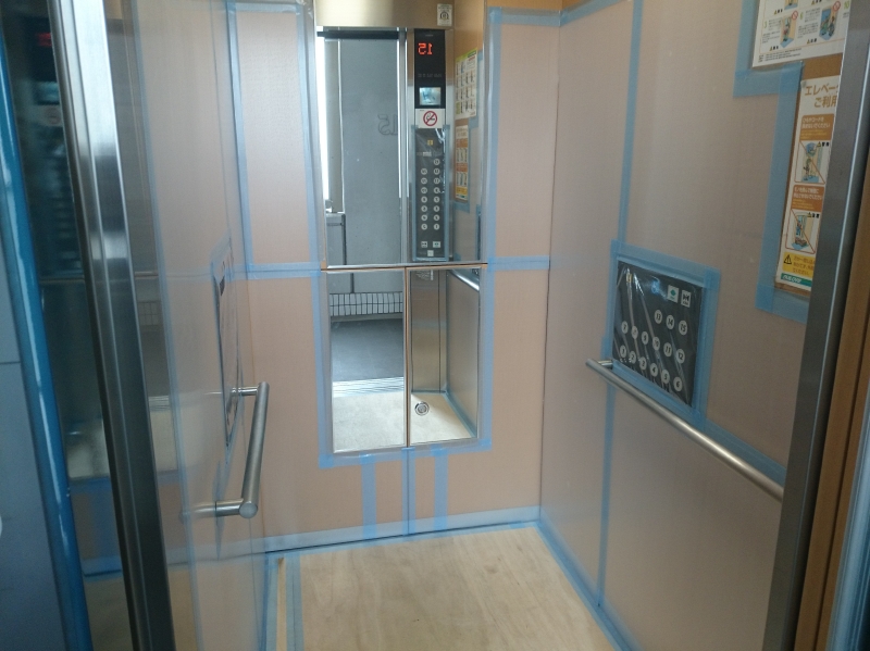 エレベーター内の養生。奥の扉は救急時に担架やストレッチャーなどが搬入できるようにするトランクルームなので、開閉できるように養生します。